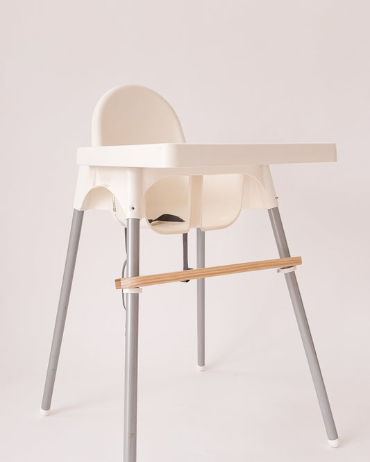 Pousa pés em madeira instalado numa cadeira Antilop do IKEA, com suporte ajustável.