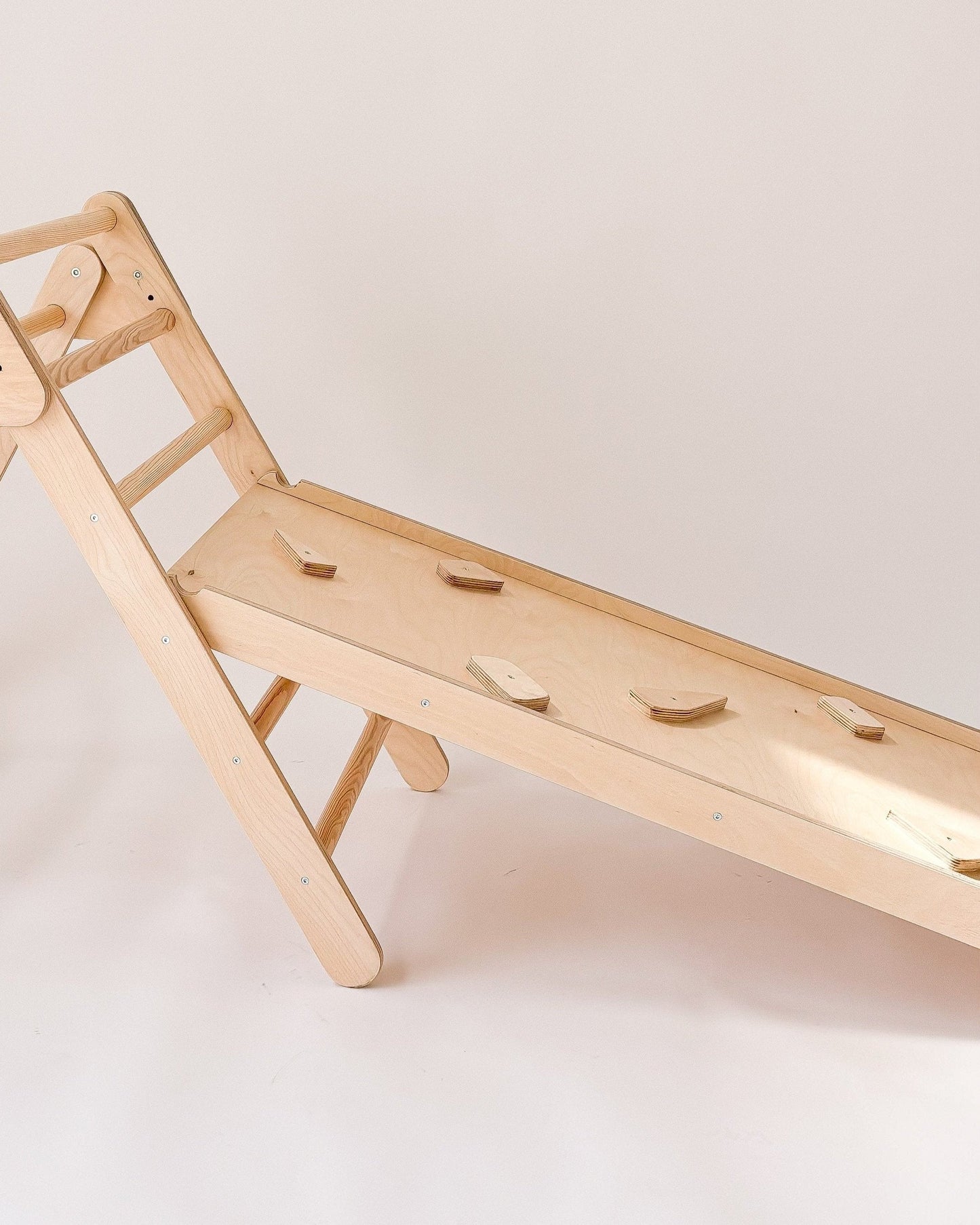 Rampa de escalada reversível com face lisa para escorregar e outra com apoios para subir.