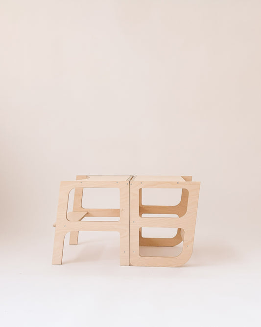 Estrutura 2 em 1 para autonomia infantil: torre para bancada e mesa para atividades.