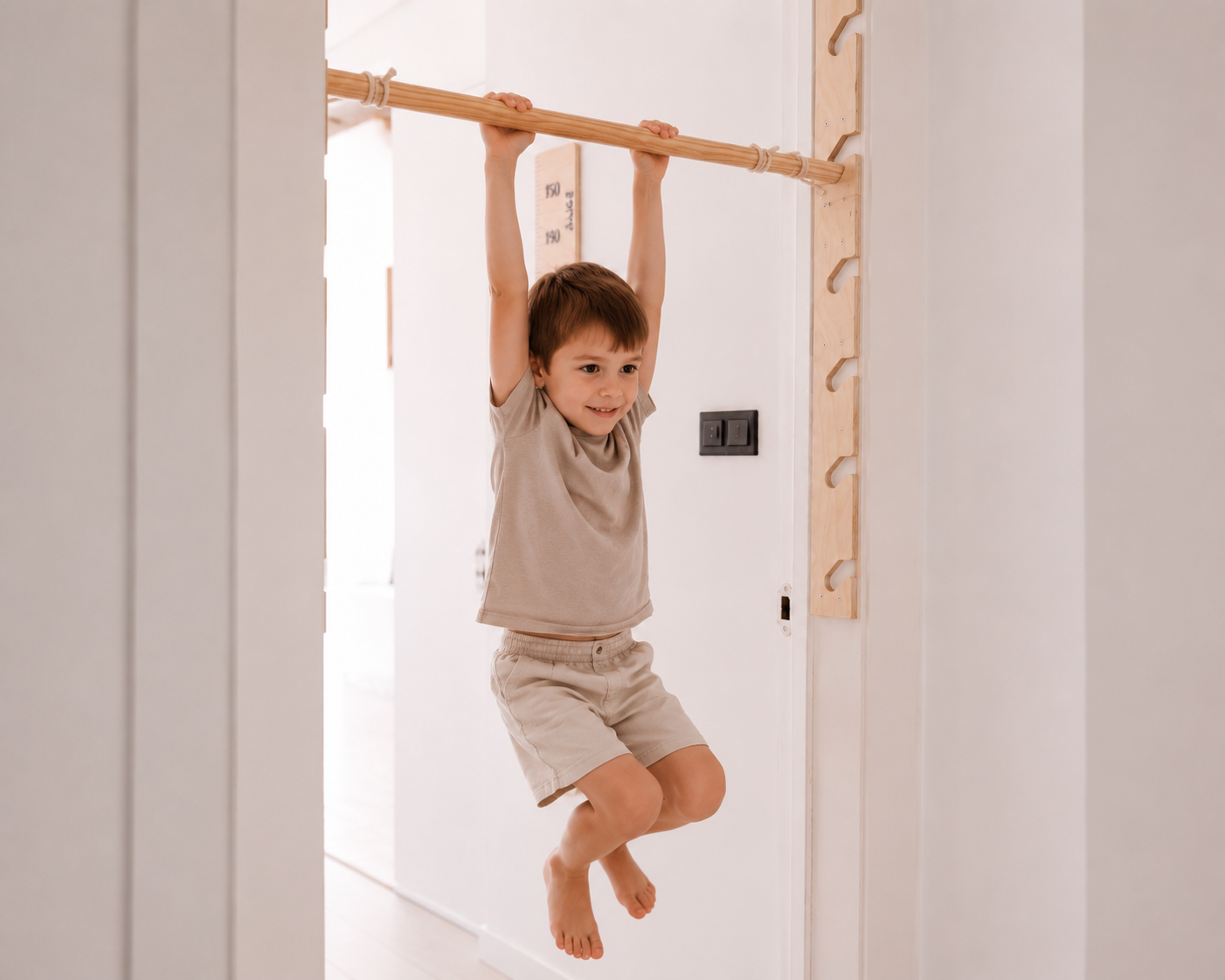 Criança suspensa numa barra fixa no vão de uma porta, dentro de casa