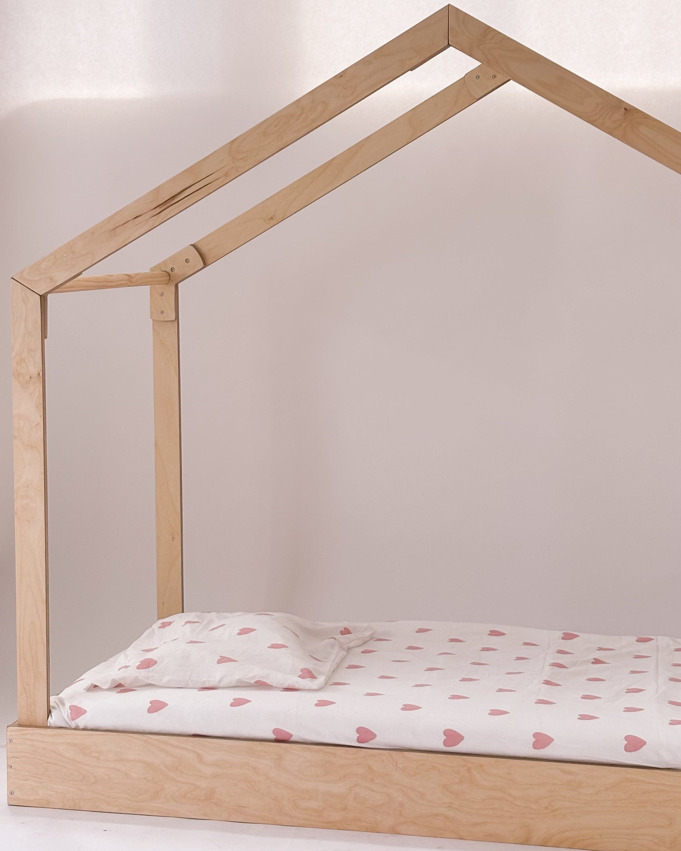 Cama casinha Montessori em madeira, baixa e sem grades, feita num quarto infantil