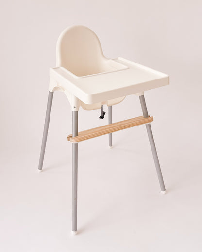 Apoio de pés infantil para cadeira de refeição, feito em pinho com fixação em PVC.