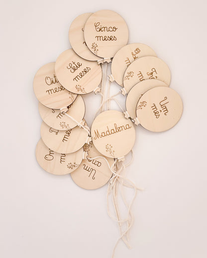 Milestone com cordão ajustado à mão do bebé, ideal para sessões fotográficas mensais