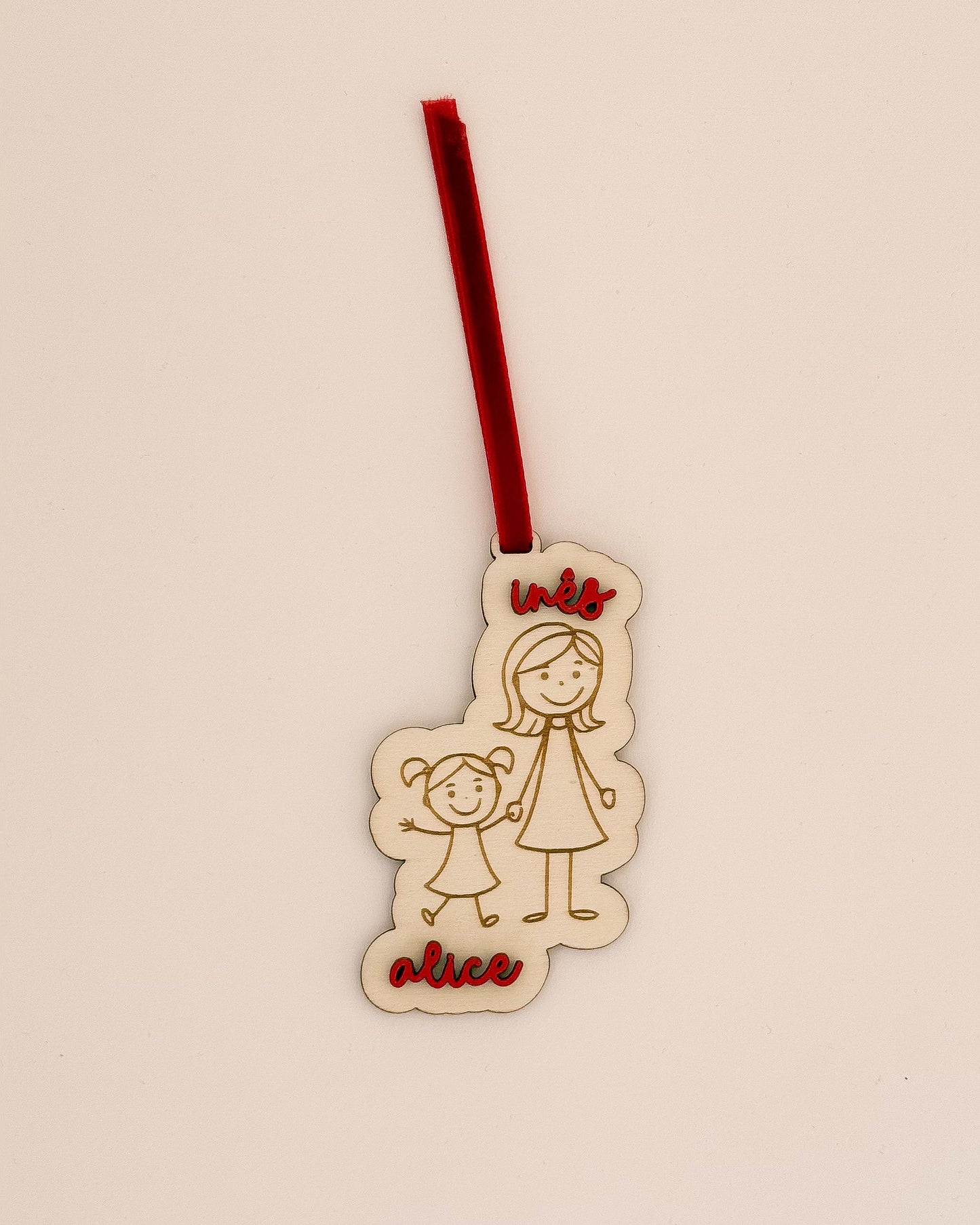 Pendente de Natal personalizado em madeira com desenho de família e nomes gravados, com fita vermelha – feito em Portugal pela TOCA.