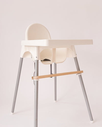 Pousa pés em madeira instalado numa cadeira Antilop do IKEA, com suporte ajustável.