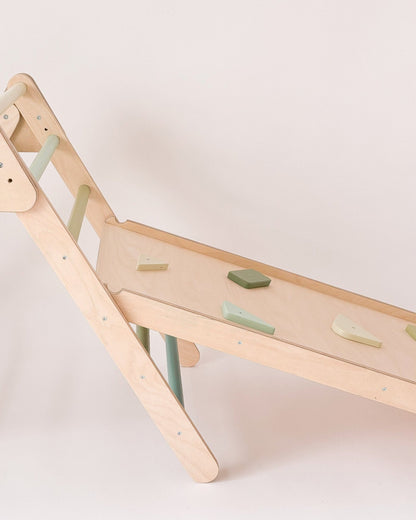 Rampa infantil encaixada num triângulo de Pikler, ideal como complemento de escalada.