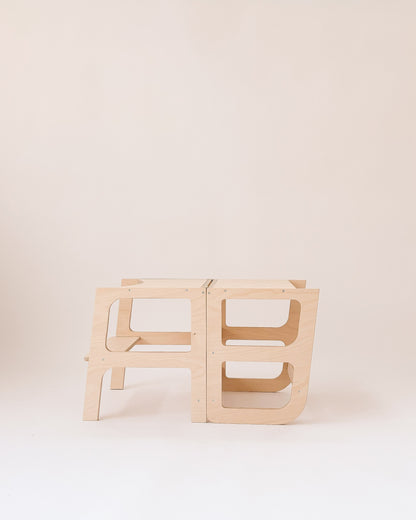 Estrutura 2 em 1 para autonomia infantil: torre para bancada e mesa para atividades.