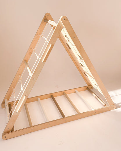 Triângulo Pikler com cordas, degraus e parede de escalada para desenvolvimento motor infantil.